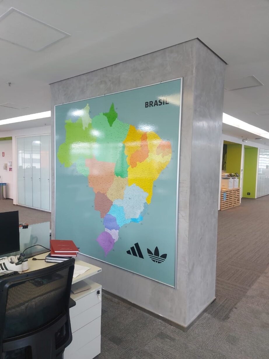 BRASIL CIDADES quadro com o mapa do brasil com estados coloridos e municípios, fundo azul acinzentado em uma parede cinza do escritório da adidas
